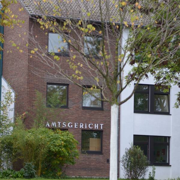 Das Amtsgerichtsgebäude in Euskirchen mit Bäumen im Vordergrund.