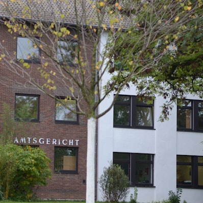 Das Amtsgerichtsgebäude in Euskirchen mit Bäumen im Vordergrund.