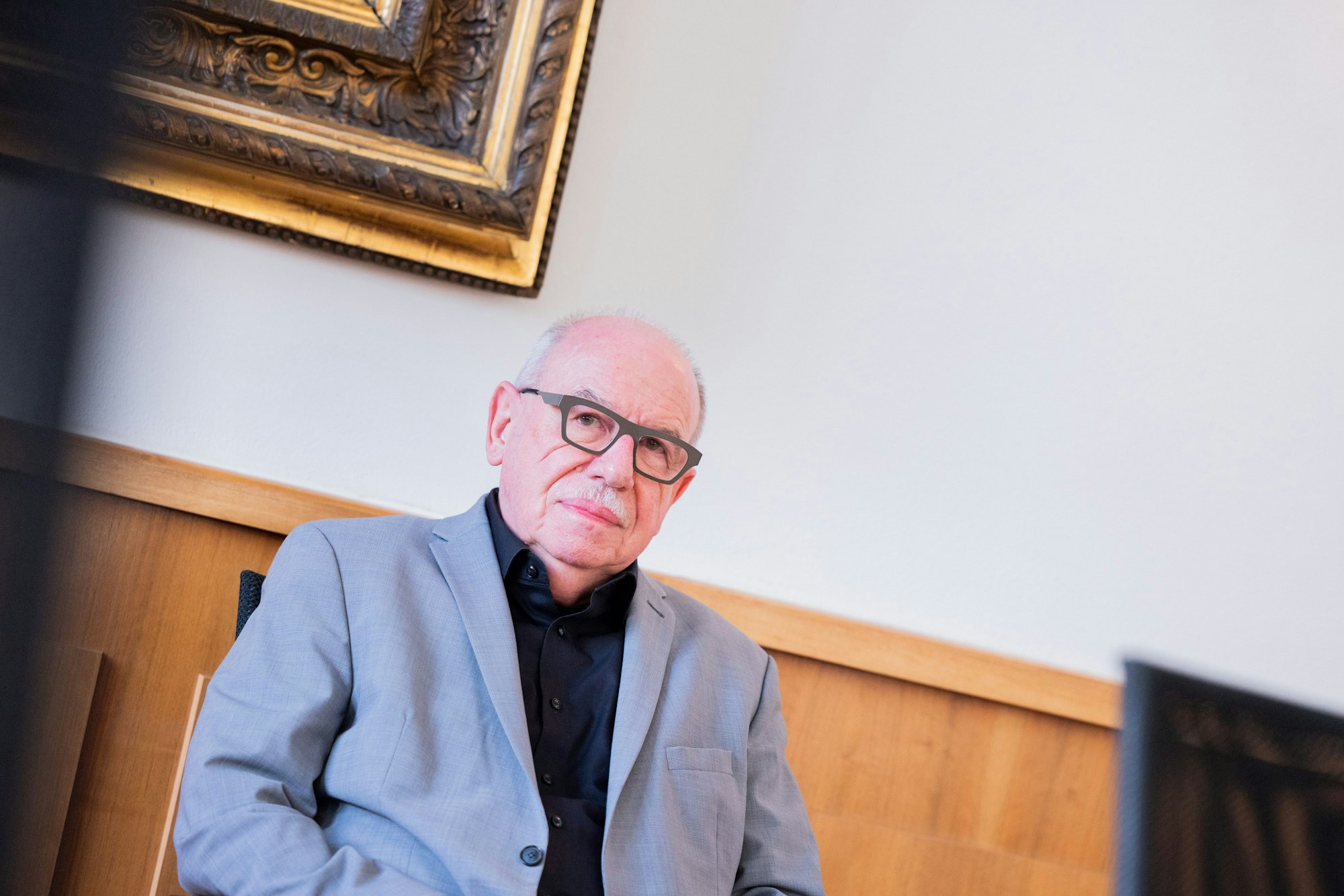Ghostwriter Heribert Schwan sitzt in einem Gerichtssaal des Oberlandesgerichtes