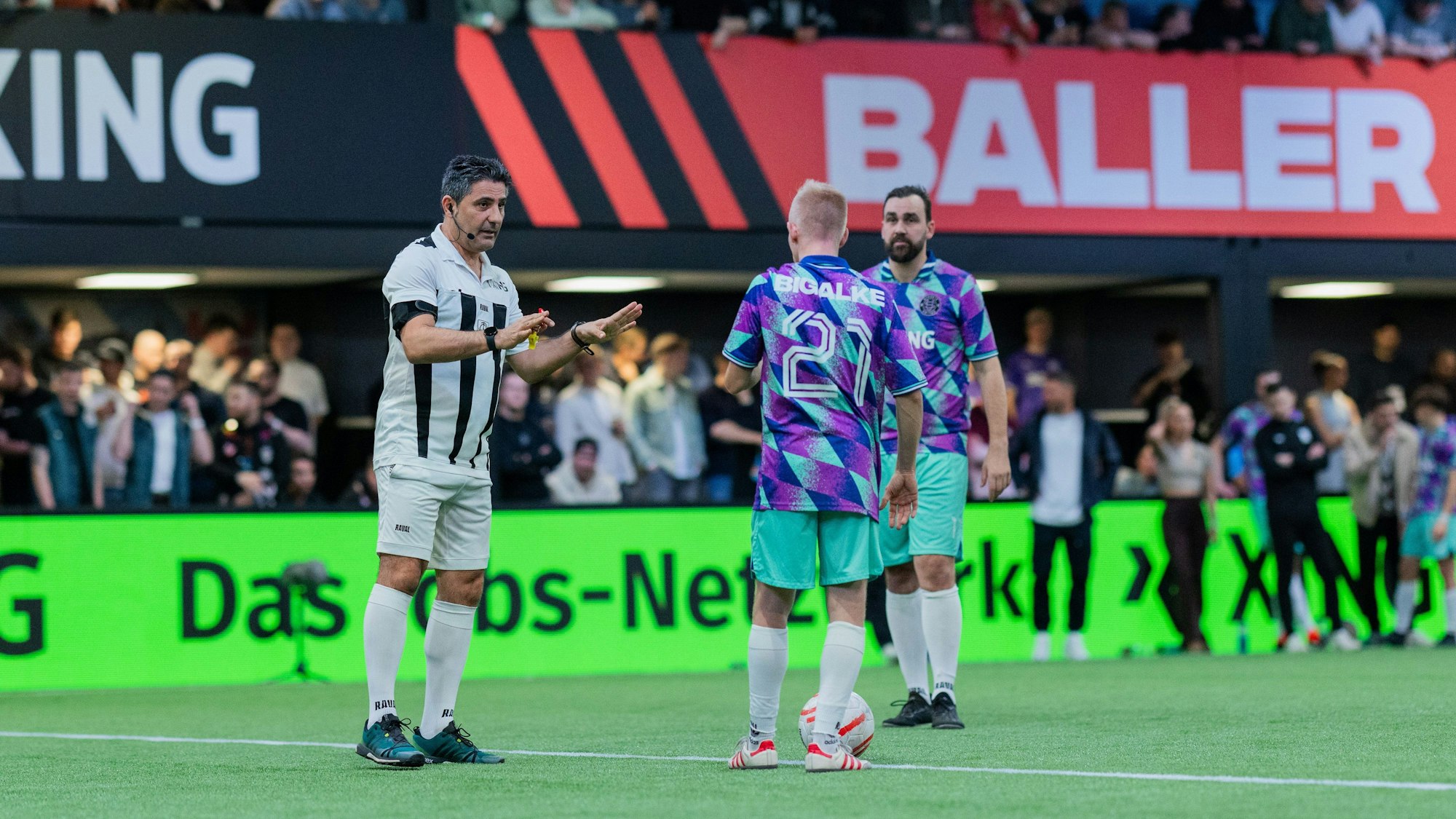 Babak Rafati, ehemaliger Bundesligaschiedsrichter, spricht auf dem Spielfeld in der „Baller League“ in Köln mit dem ehemaligen Bundesligaspieler Sascha Bigalke von Streets United.