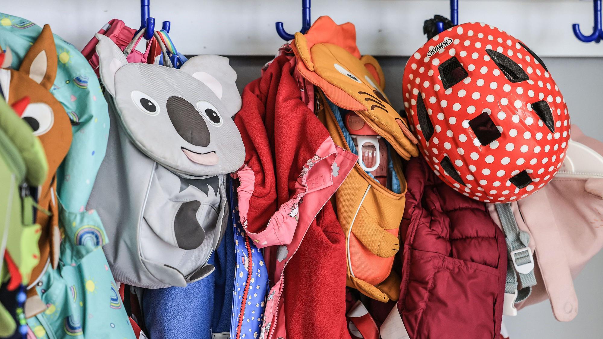Garderobe und Taschen von Kindern hängen im Flur einer Kindertagesstätte.