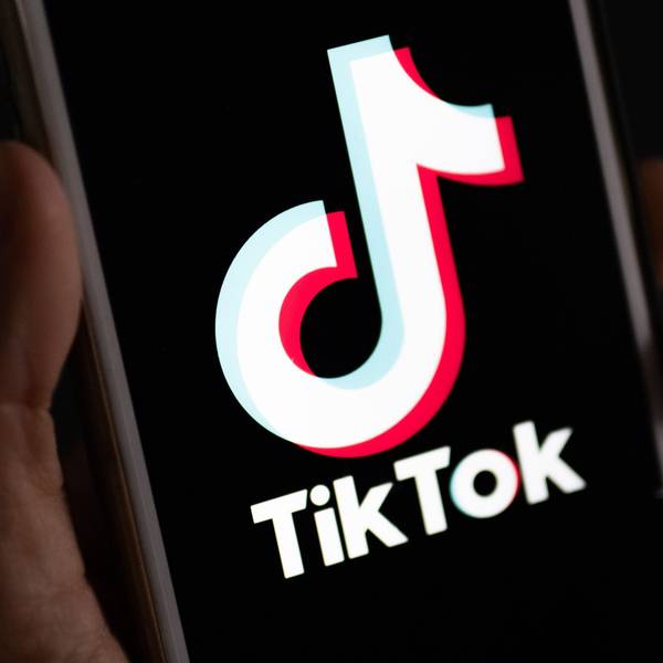 Eine Hand hält ein Smartphone in der Hand, auf dem die TikTok-App installiert ist.