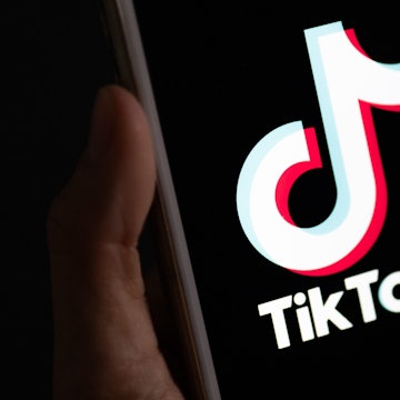Eine Hand hält ein Smartphone in der Hand, auf dem die TikTok-App installiert ist.