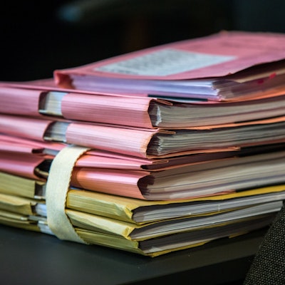 Das Bild zeigt Gerichtsakten auf einem Tisch.