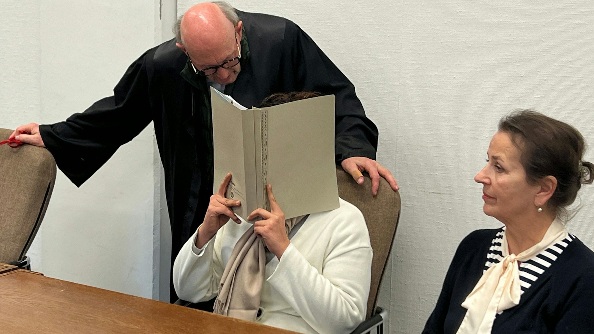 Verteidiger Günter Teworte mit einer wegen Schockanrufen Angeklagten und einer Dolmetscherin im Kölner Landgericht