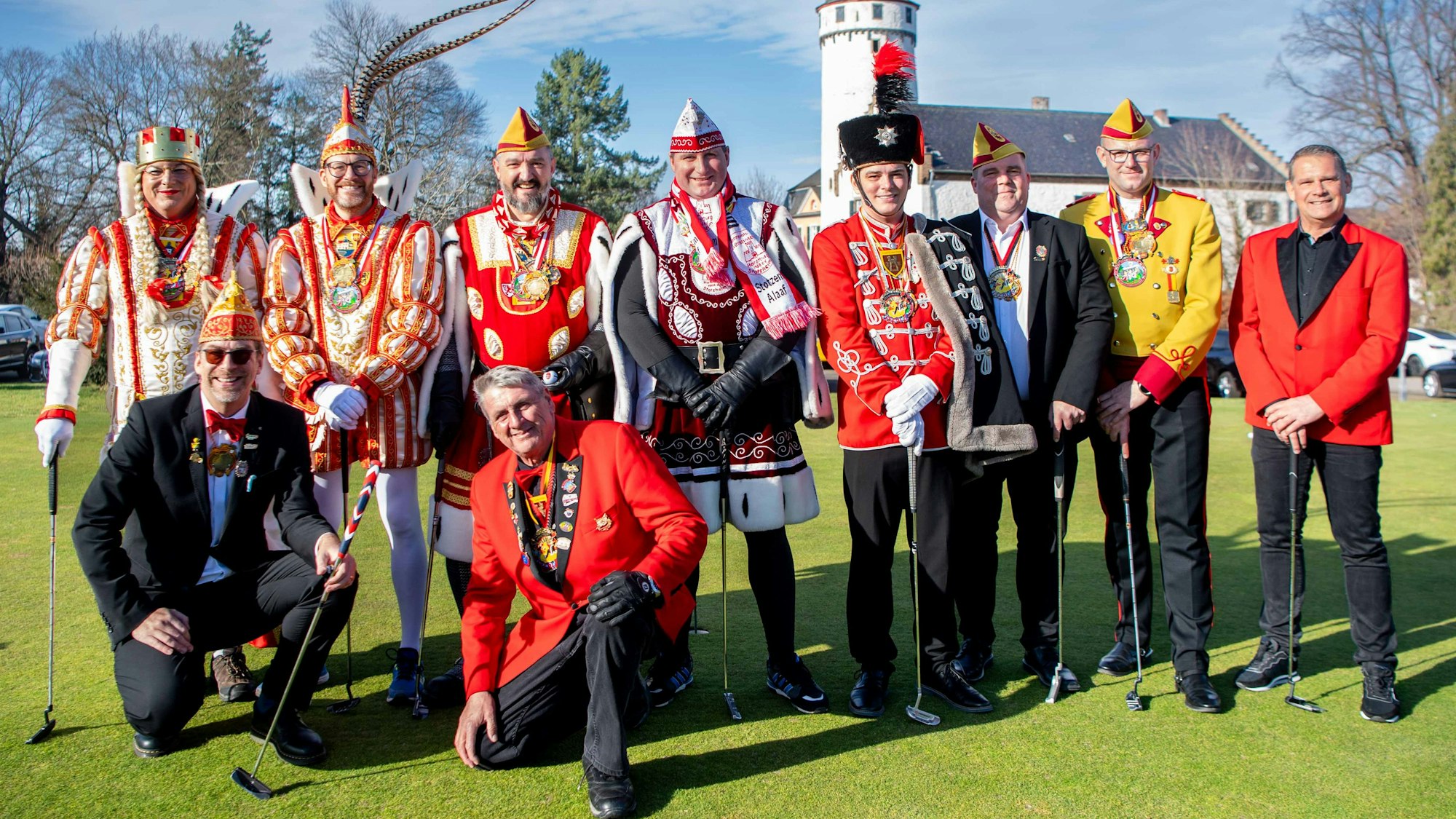 Das Bild zeigt die Euskirchener Tollitäten im Ornat auf dem Golfplatz des Golfclub Burg Zievel. Die Burg ist im Hintergrund zu sehen.