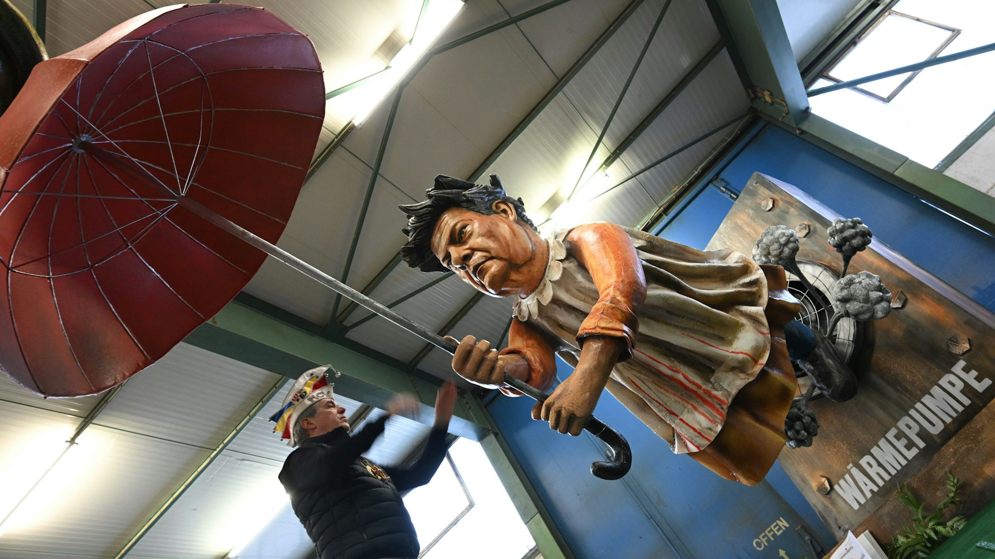 06.02.2024, Rheinland-Pfalz, Mainz: Bundeswirtschaftsminister Robert Habeck (Bündnis 90/Die Grünen) wird bei der Vorstellung der Motivwagen für den Mainzer Rosenmontagszug in der Wagenhalle des Mainzer Carneval-Vereins (MCV) als ·Fliegender Robert· präsentiert, der von einer Wärmepumpe weggepustet wird. Innen- und außenpolitischen Themen dienen als Vorlage für die närrischen Motivwagen, die am 12. Februar im närrischen Lindwurm durch die Landeshauptstadt rollen. (zu dpa: «Scholz fährt als Schiffbrüchiger beim Mainzer Rosenmontagszug mit») Foto: Arne Dedert/dpa +++ dpa-Bildfunk +++