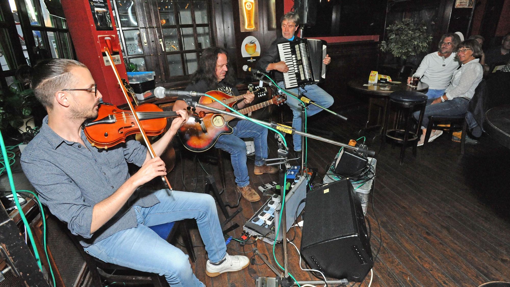 In einer Kneipe in Leverkusen machen Musiker live Musik.
