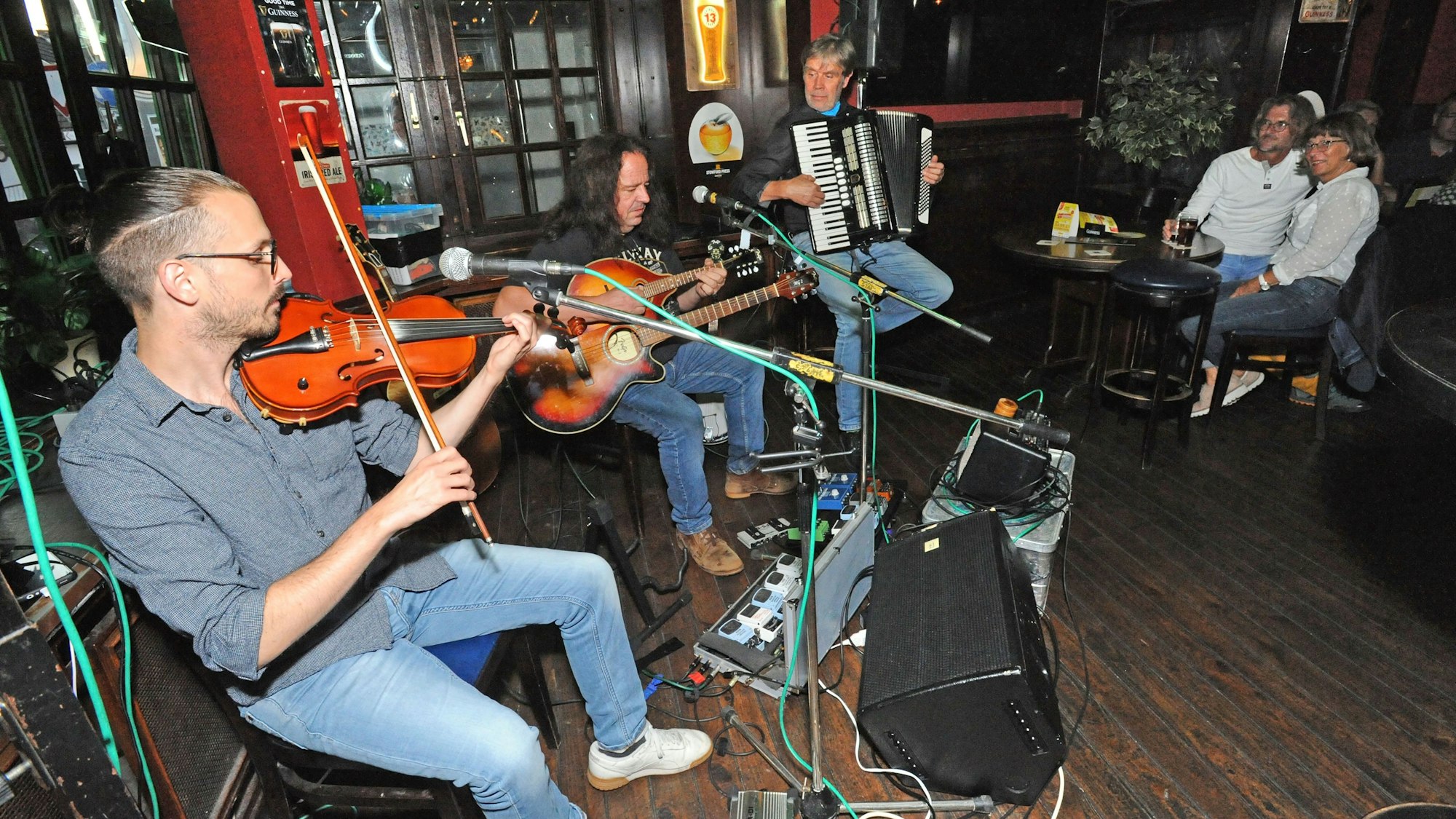 In einer Kneipe in Leverkusen machen Musiker live Musik.