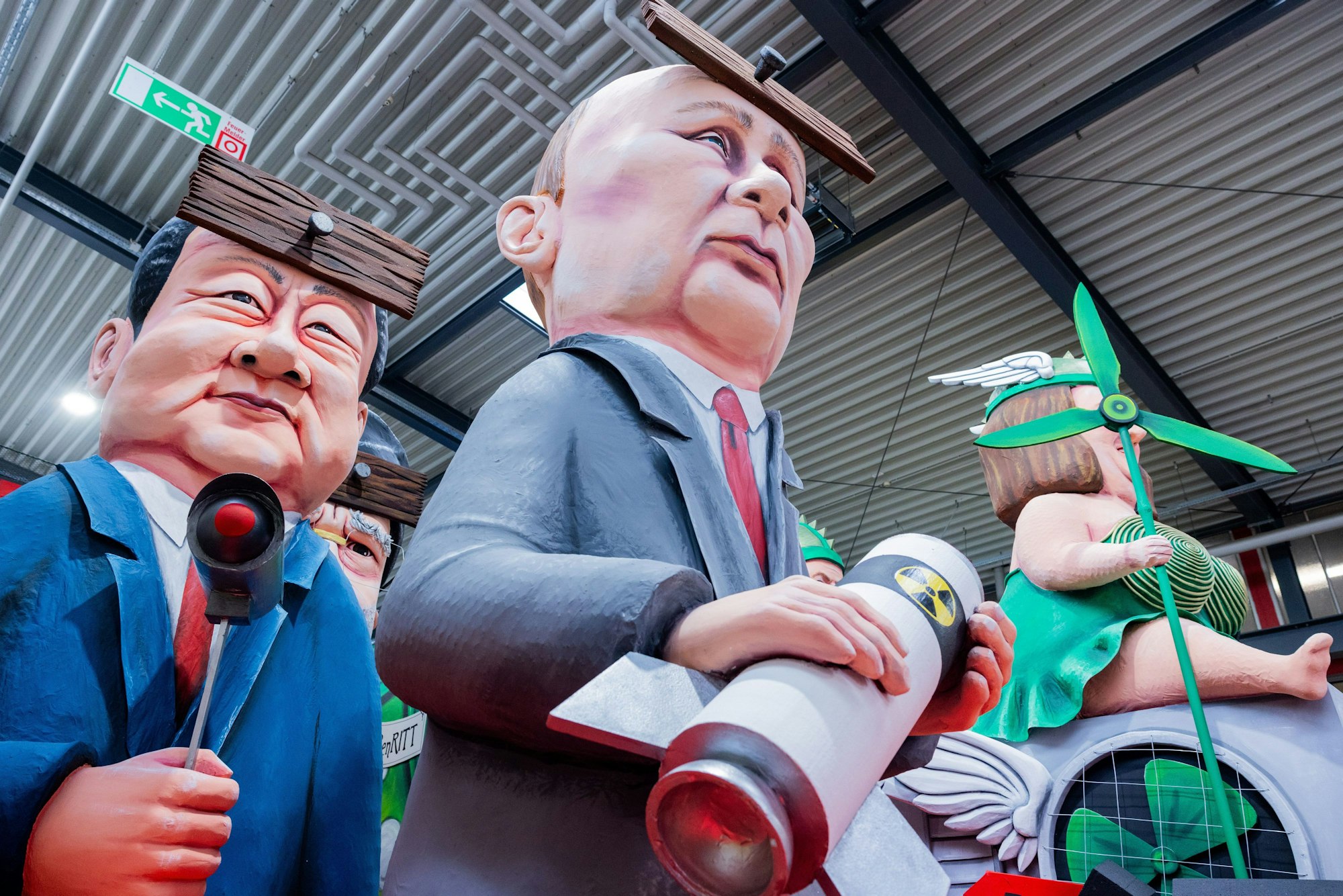 06.02.2024, Nordrhein-Westfalen, Köln: Ein Motivwagen, der Russlands Präsident Wladmir Putin (Russland) mit Atomrakete, Xi Jinping (l), Chinas Staats- und Parteichef, und Irans Religionsführer Ajatollah Ali Chamenei (hinten) jeweils mit einem Brett vor dem Kopf zeigen soll, steht beim Richtfest für den Kölner Rosenmontagszug im Karnevalsmuseum. Foto: Rolf Vennenbernd/dpa +++ dpa-Bildfunk +++