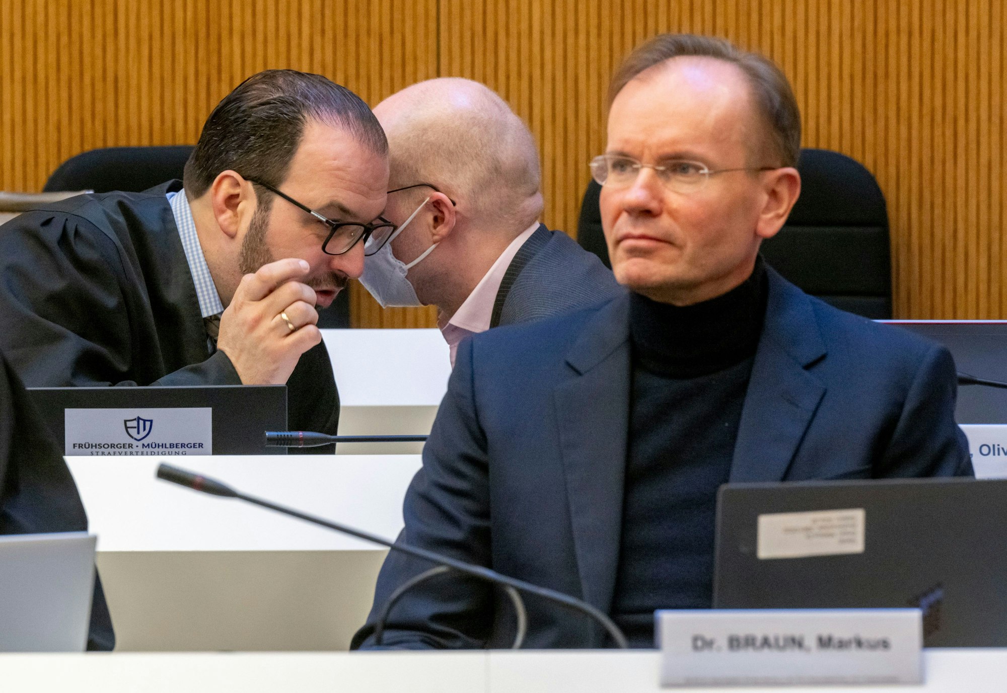 Markus Braun (r), früherer Vorstandschef von Wirecard sitzt im Gerichtssaal, im Hintergrund berät sich Oliver Bellenhaus mit seinem Anwalt.
