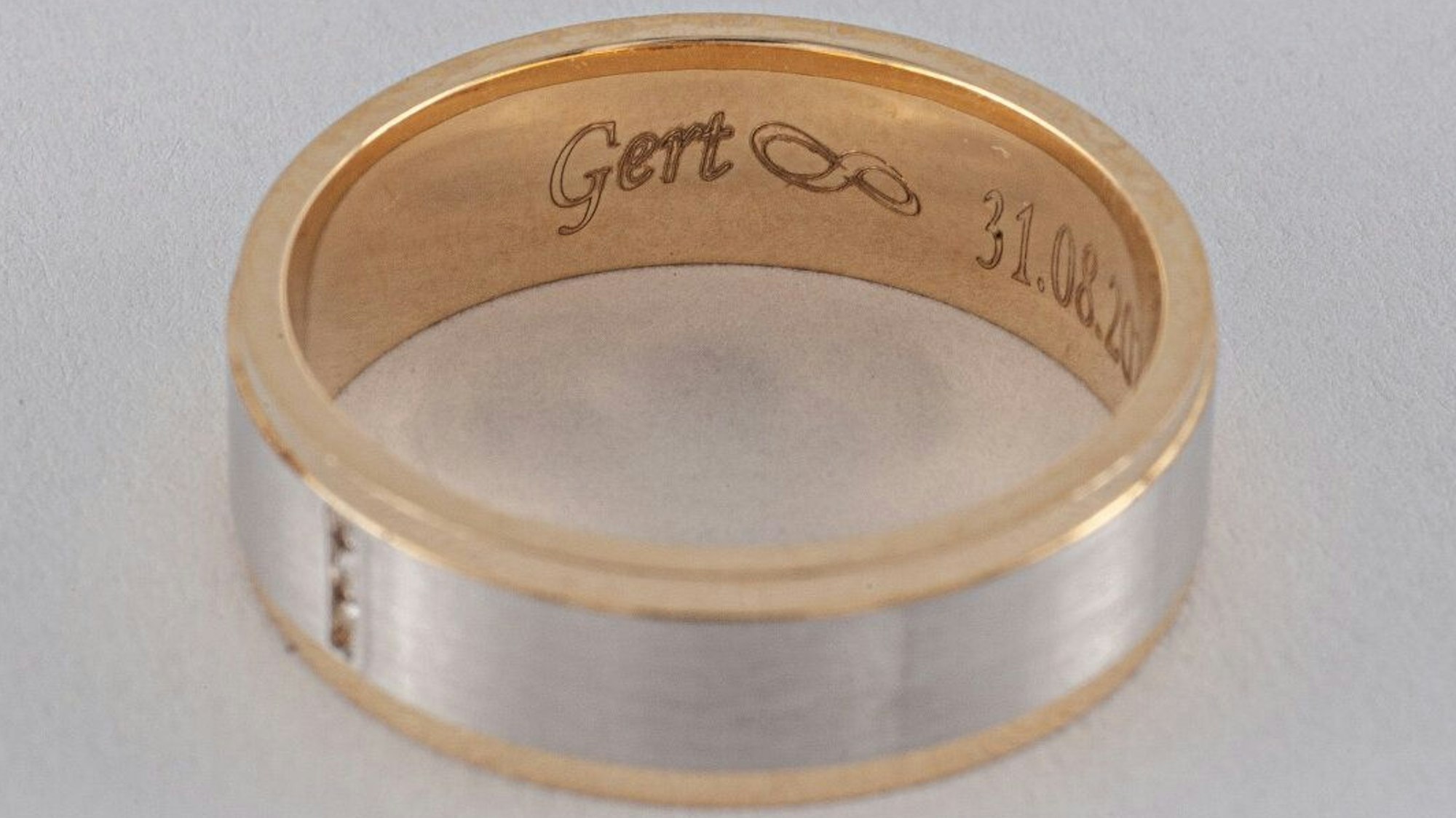 Zu sehen ist ein Goldring mit Gravur.