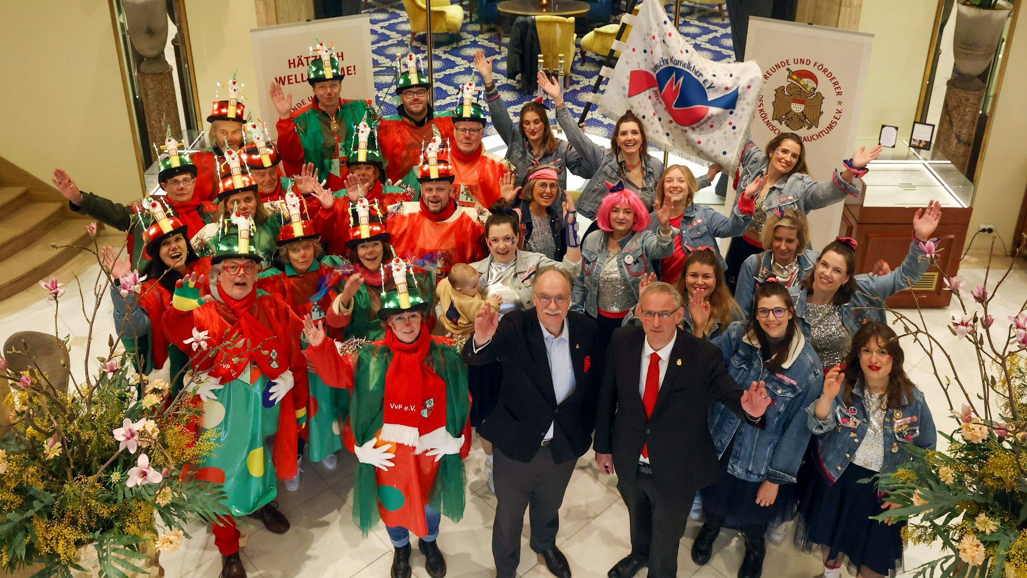 Menschenmenge von oben mit zwei Herren im Anzug dahinter verkleidete Personen