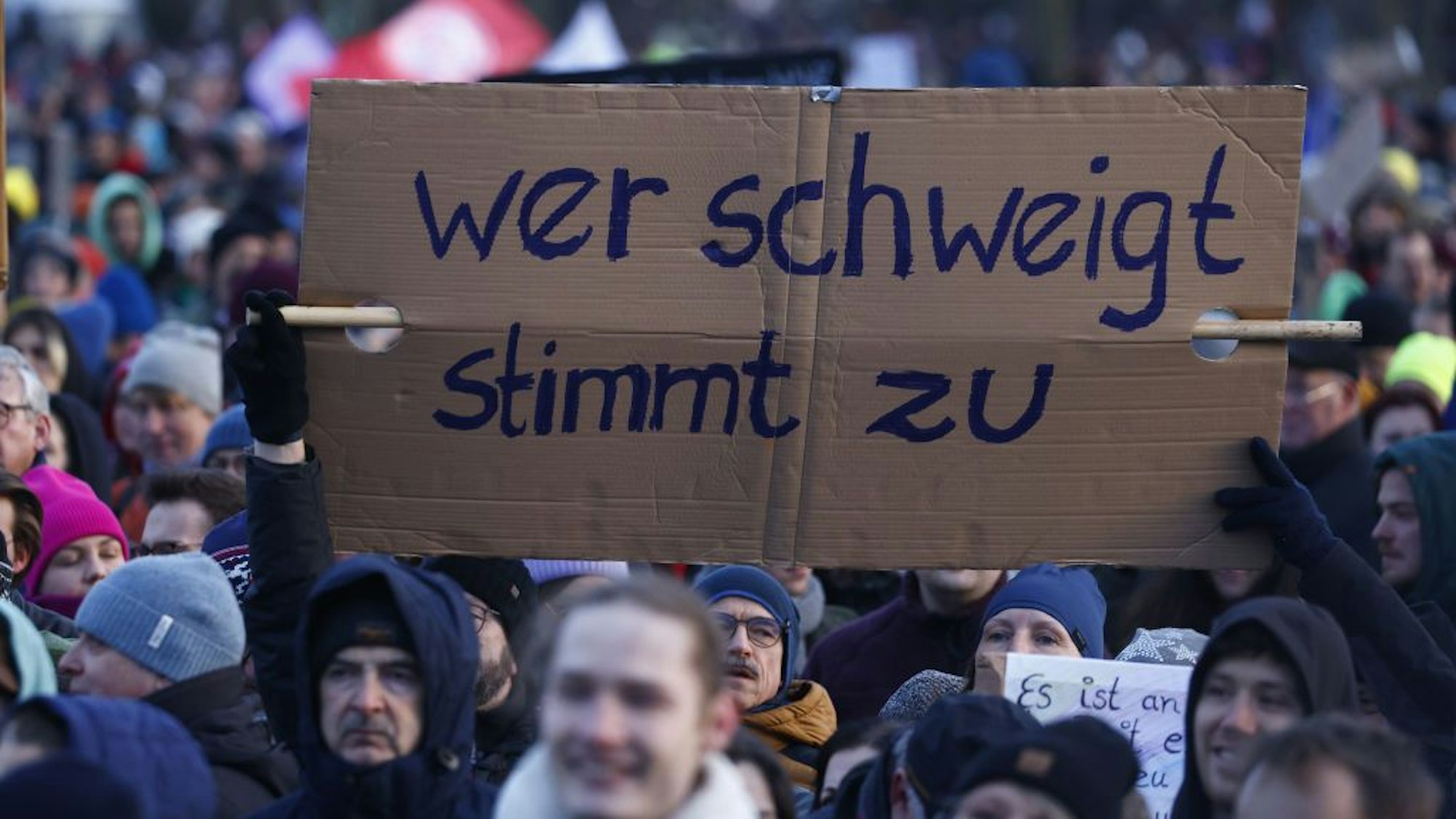 Menschen halten ein Schild in die Höhe bei einer Demo gegen Rechtsextremismus in Berlin.