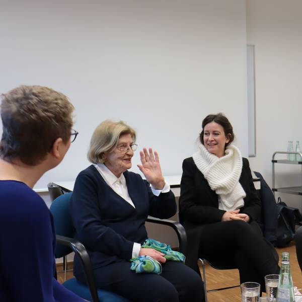 Eva Szepesi und einige ihrer Zuhörerinnen und Zuhörer sitzen auf Stühlen nebeneinander.