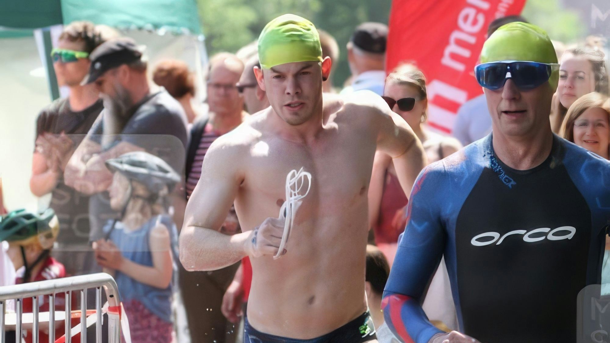 Triathlet Alexander Linßen läuft mit giftgrüner Badekappe mit freiem Oberkörper.