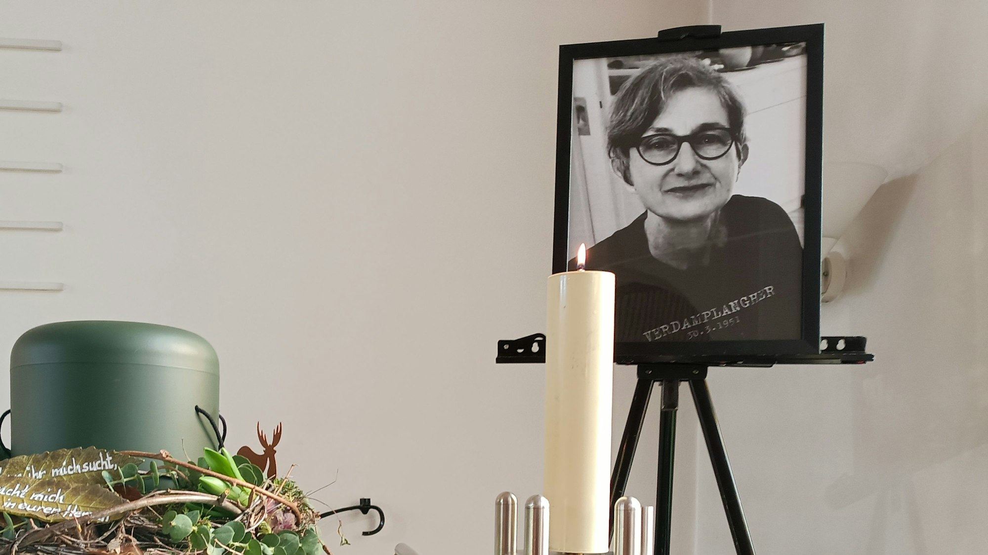 Die Urne mit der Asche von Elke Bahn, daneben eine Kerze und ein Bild der Buchhändlerin.