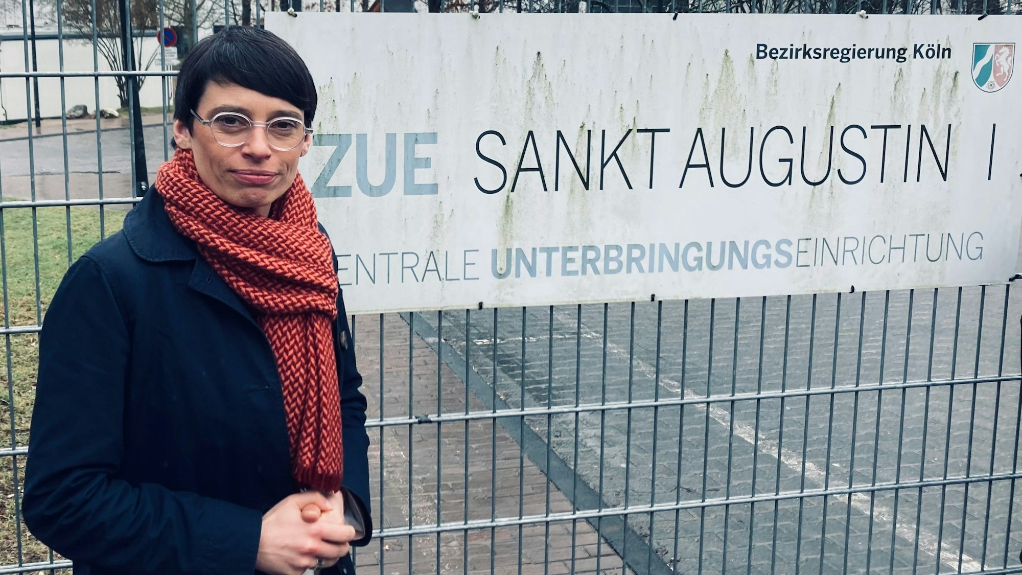Ministerin Paul am Eingang der Flüchtlingsunterkunft in Sankt Augustin