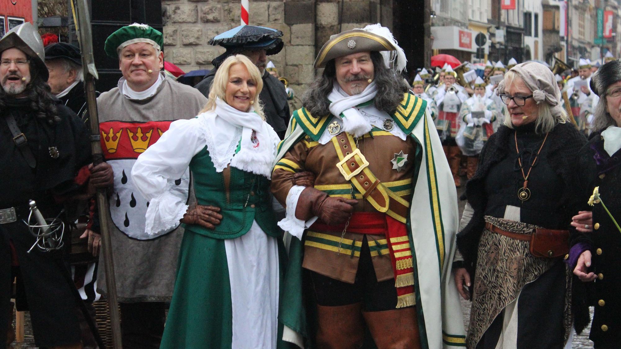 Eine Gruppe an Menschen steht vor der Severinstorburg. In der Mitte stehen Jan und Griet.