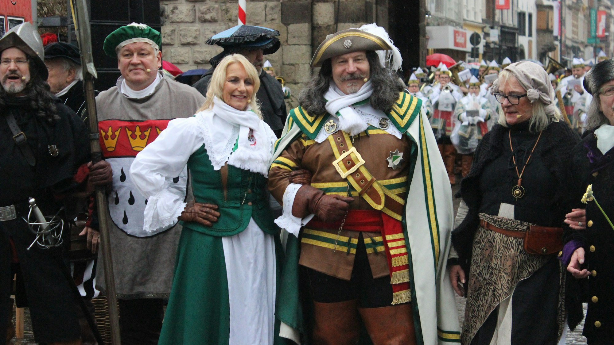 Eine Gruppe an Menschen steht vor der Severinstorburg. In der Mitte stehen Jan und Griet.