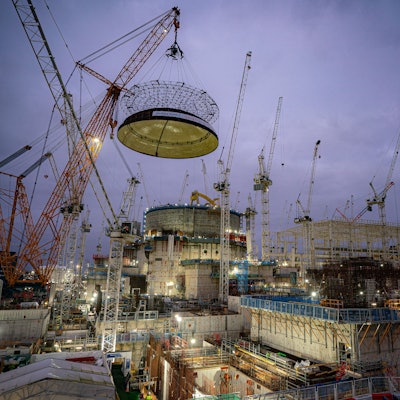 Ingenieurteams heben mit dem größten Kran der Welt - Big Carl - eine 245 Tonnen schwere Stahlkuppel auf das erste Reaktorgebäude von Hinkley Point C auf der Baustelle des Kernkraftwerks in Bridgwater, Somerset.