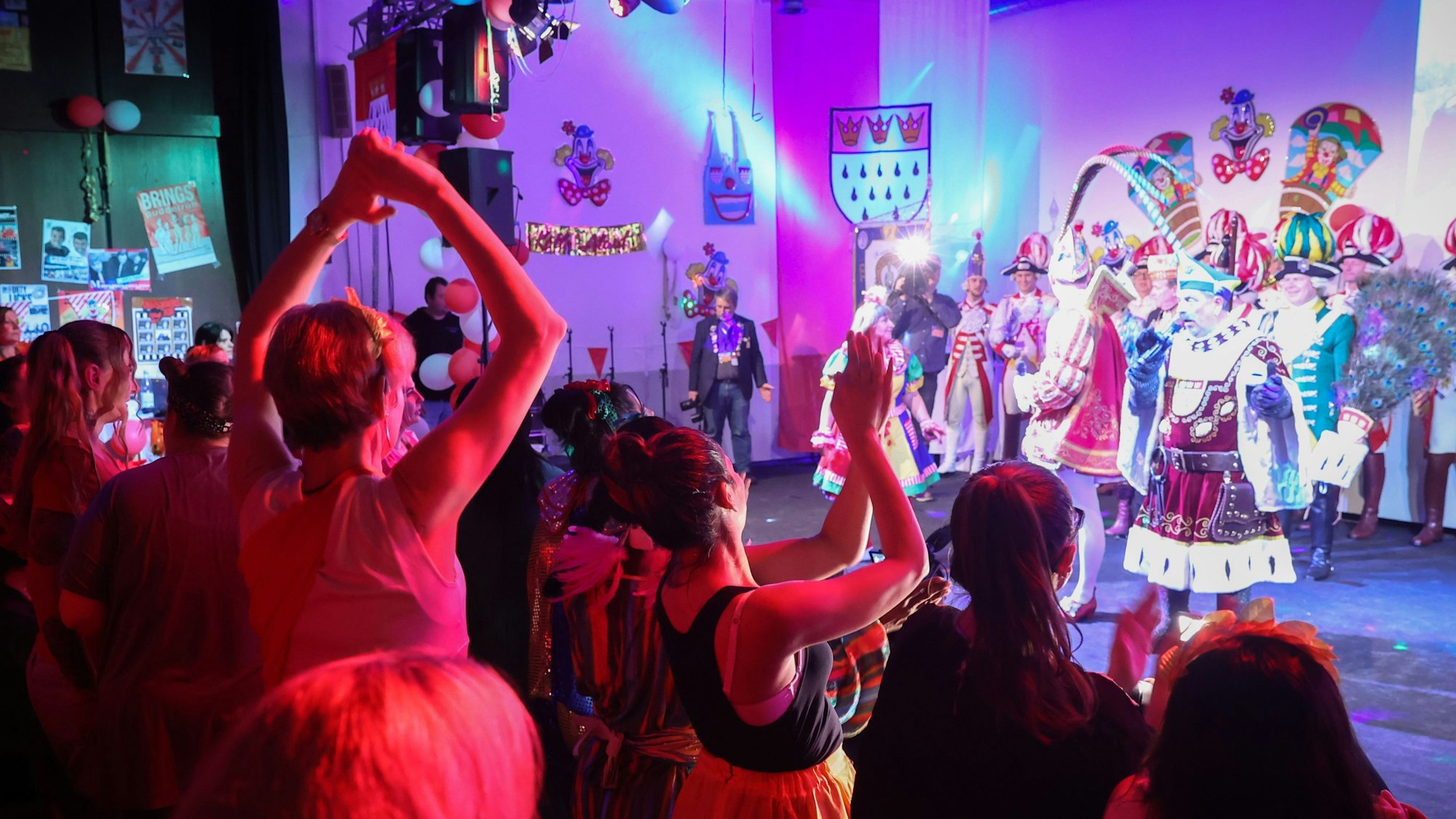 Bei der Karnevalssitzung in der JVA Köln für weibliche Inhaftierte stehen Frauen vor einer Bühne.