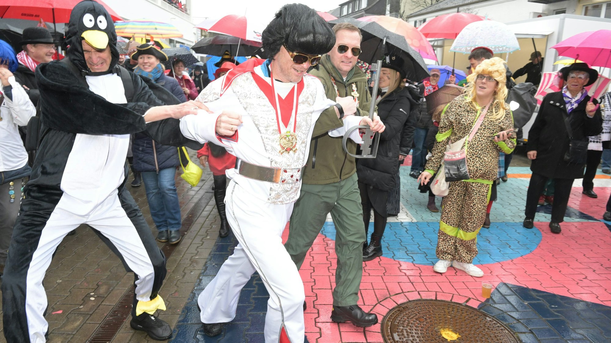 Zwei Beigeordnete (Pinguin“ Migenda, „Militärexperte“ Eggert) versuchen ihren Elvis zu halten - vergebens.