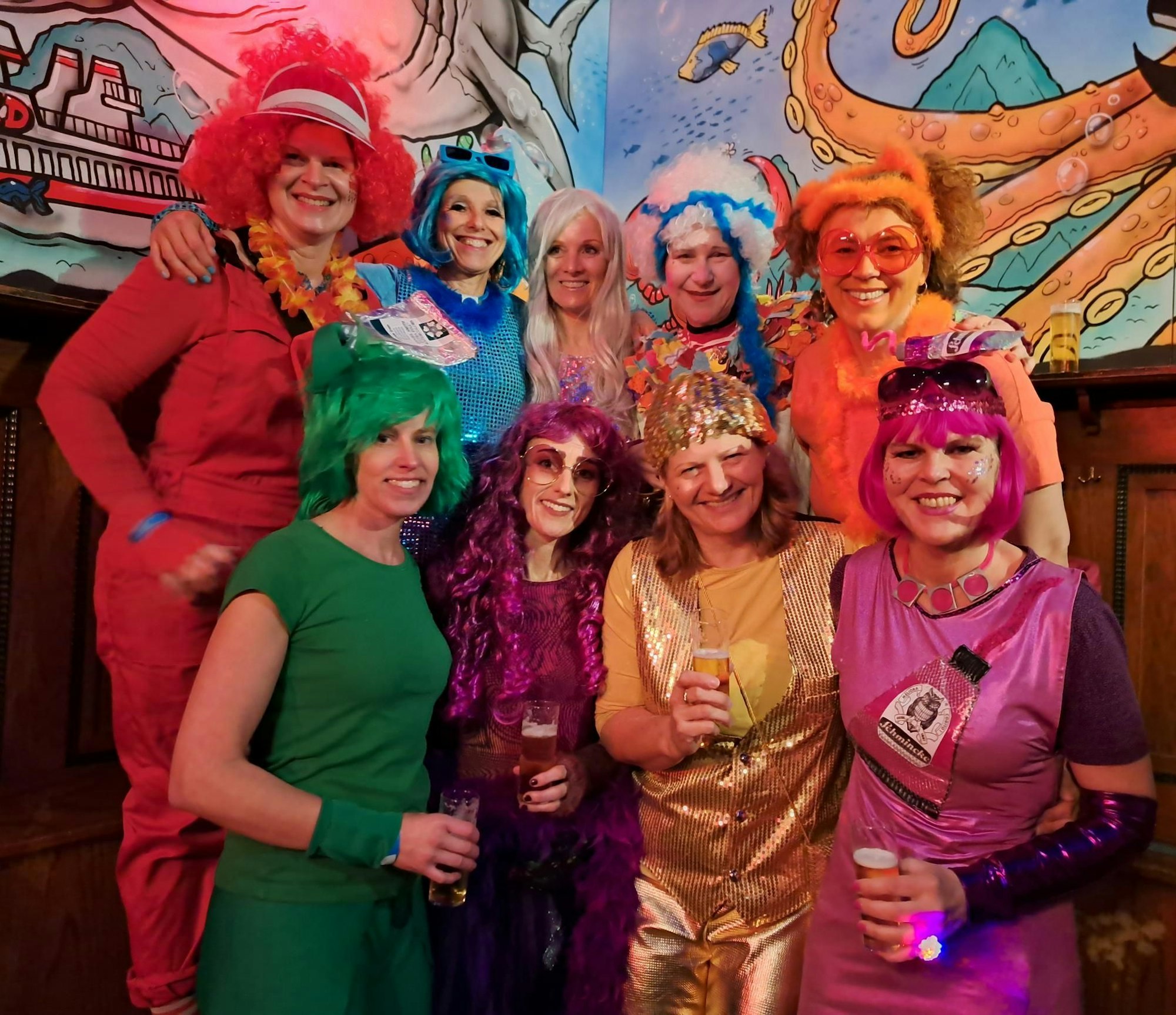 Neun bunt verkleidete Frauen blicken in die Kamera.