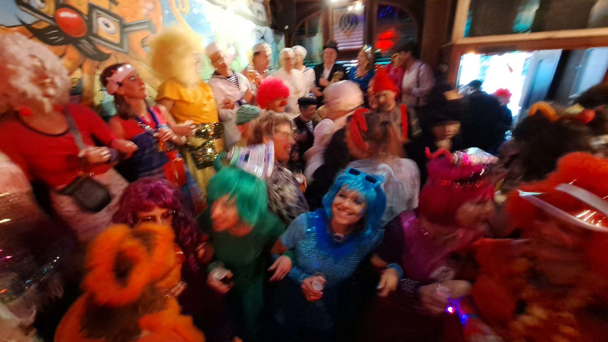 Kostümierte Menschen feiern in einer Kneipe.