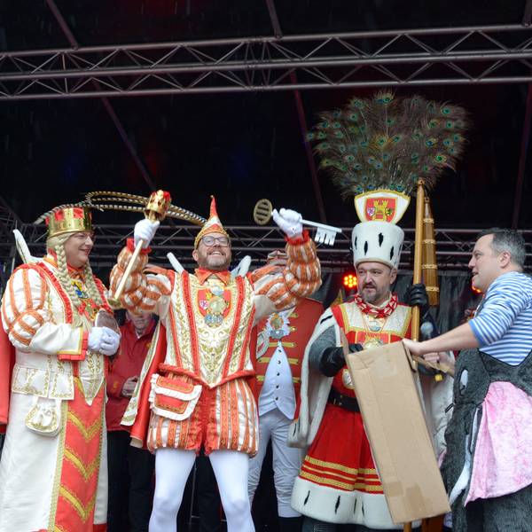 Da ist das Ding! Prinz Tobi I., flankiert von Jungfrau Martina und Bauer Sascha, präsentiert den Stadtschlüssel, den er in die Höhe reckt. Am Bildrand steht der geschlagene Bürgermeister Sacha Reichelt.