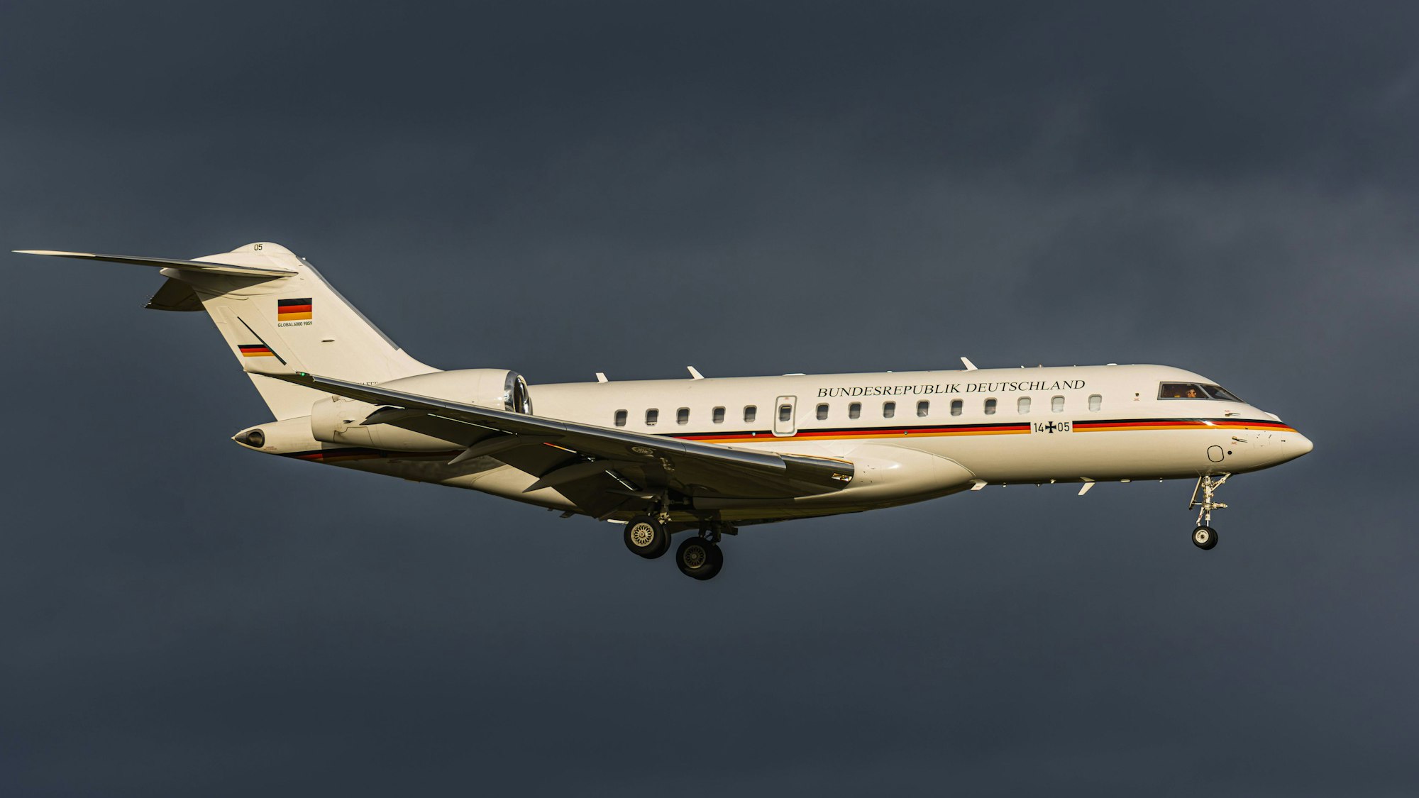 Ein Flugzeug der deutschen Bundesregierung vom Typ Bombardier Global 6000 fliegt vor einer dunklen Unwetterwolke. (Symbolbild)