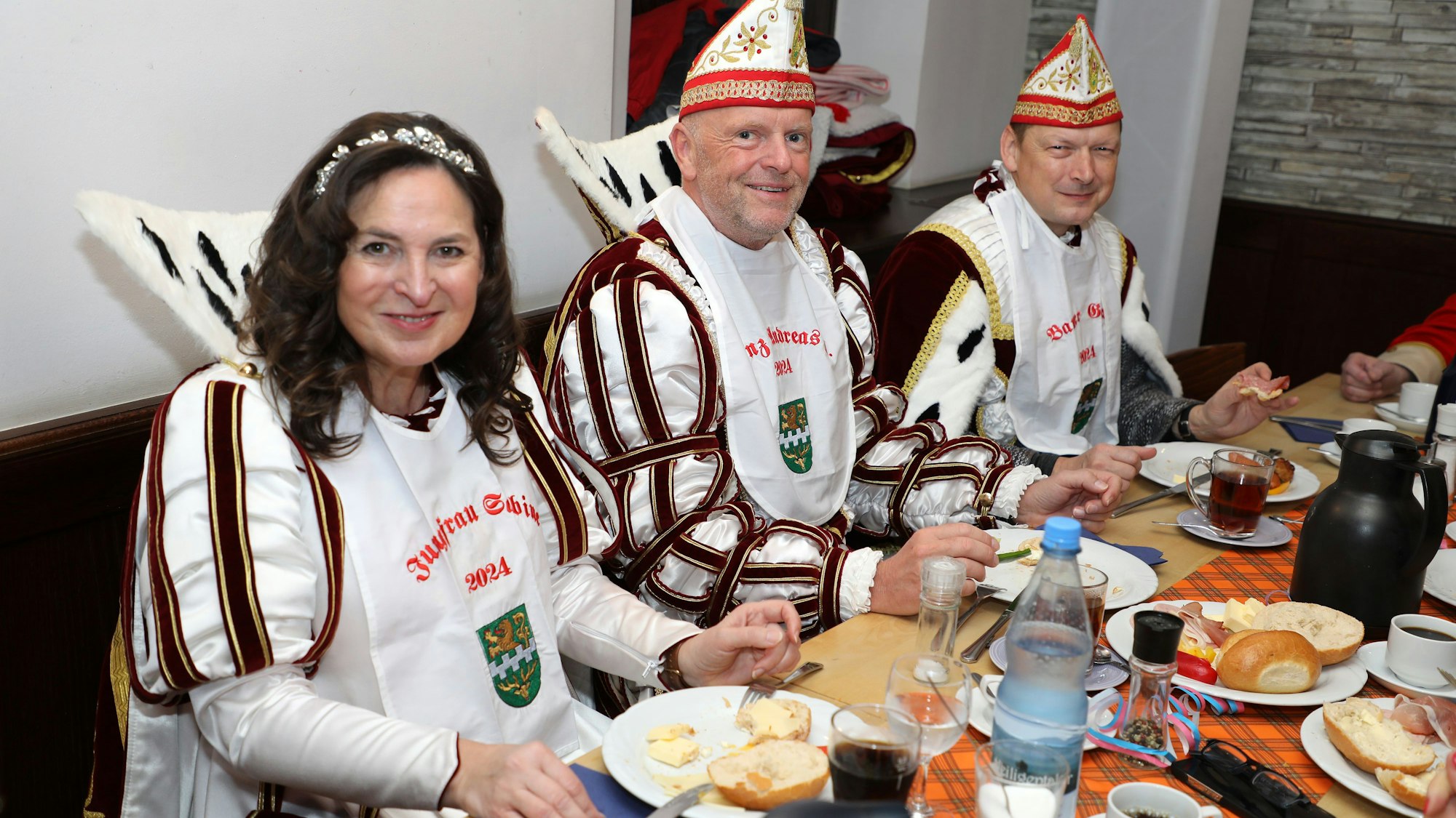 Jungfrau Sabine, Prinz Andreas I. und Bauer Gerd sitzen an einem Tisch in der Hofburg Lindenhof in Moitzfeld beim Frühstück.