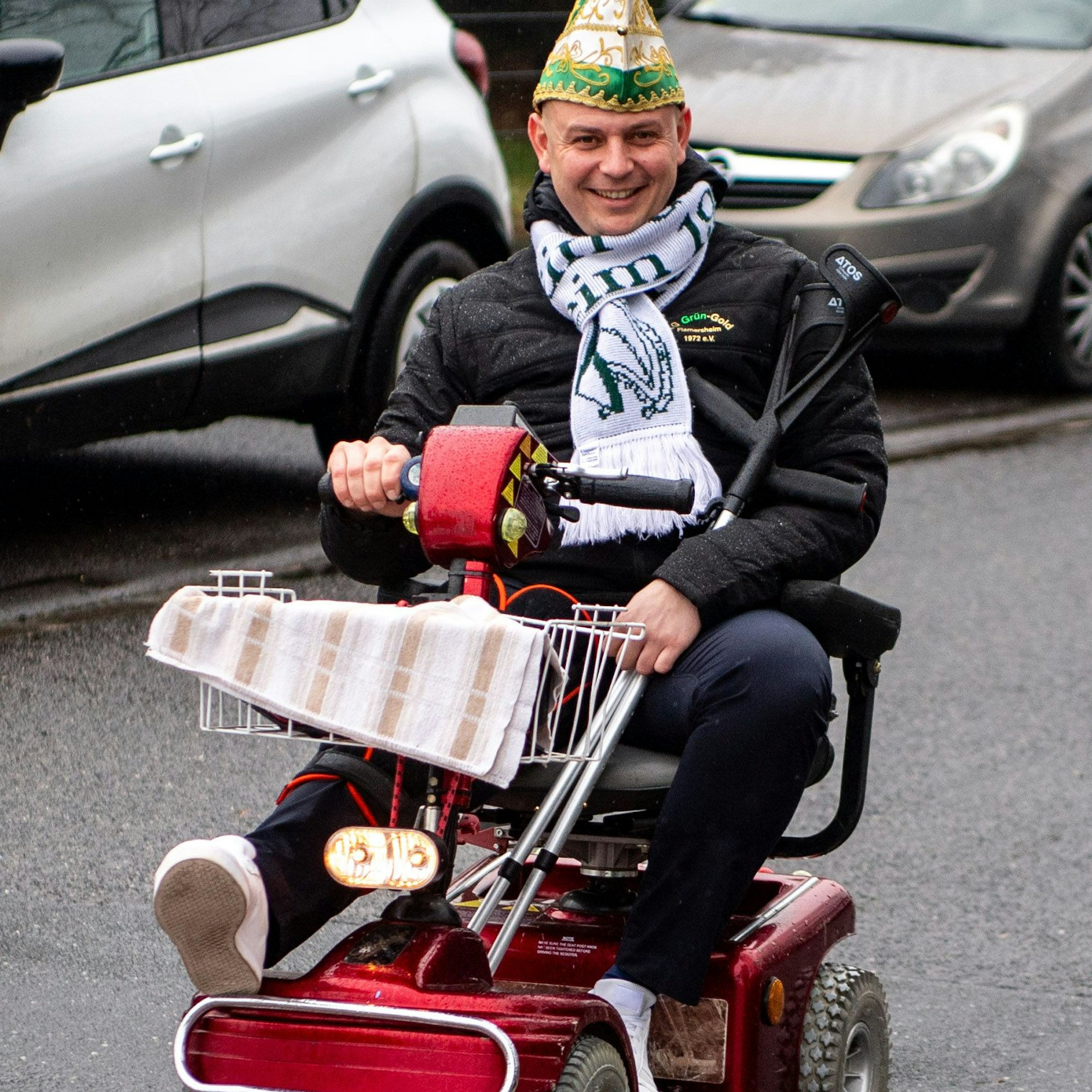 Der Präsident Philipp Kahnert sitzt mit Narrenkappe in einem Elektro-Rollstuhl.