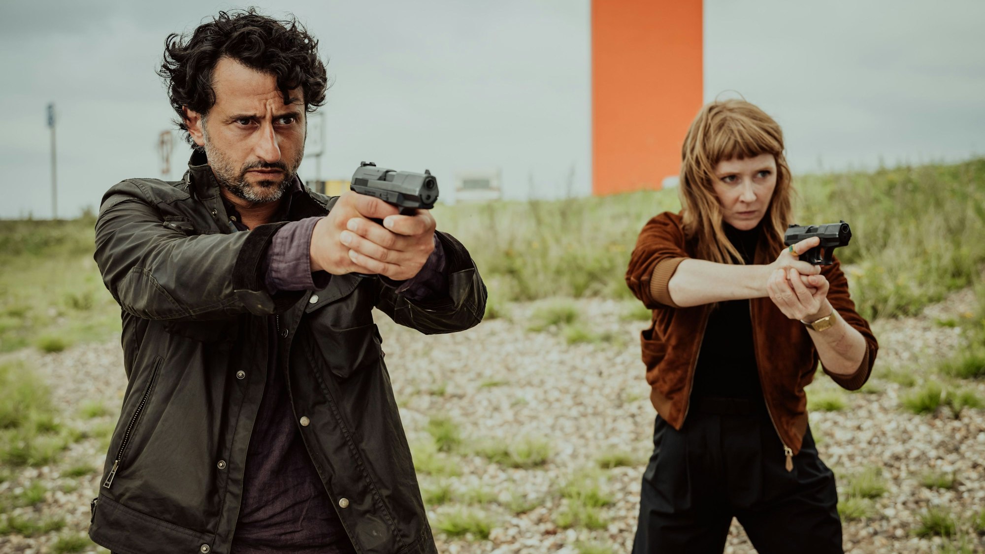 Zwei Polizisten zielen mit ihren Waffen auf jemanden, den wir nicht sehen können.