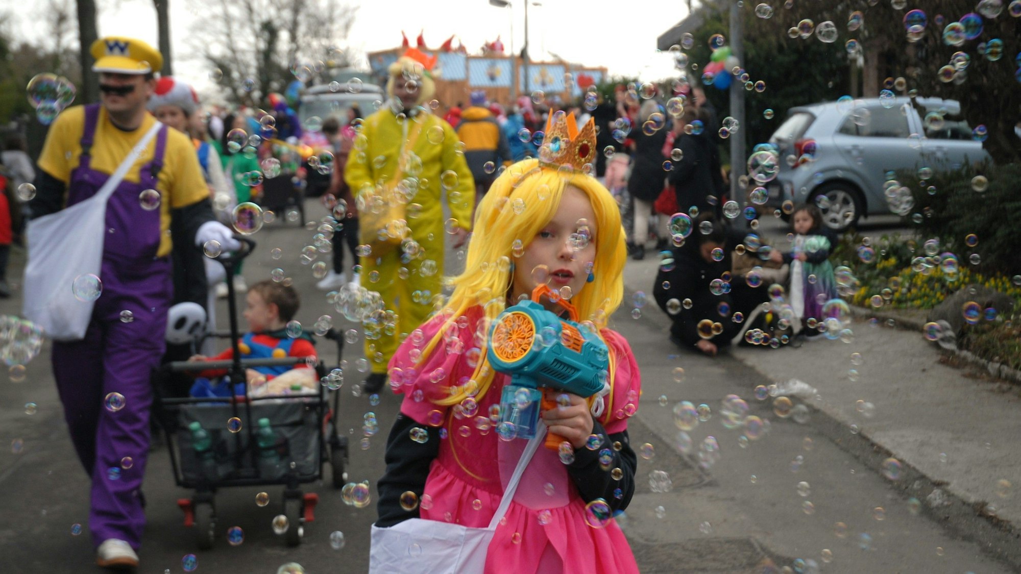 Ein als Prinzessin verkleidetes Mädchen macht Seifenblasen.