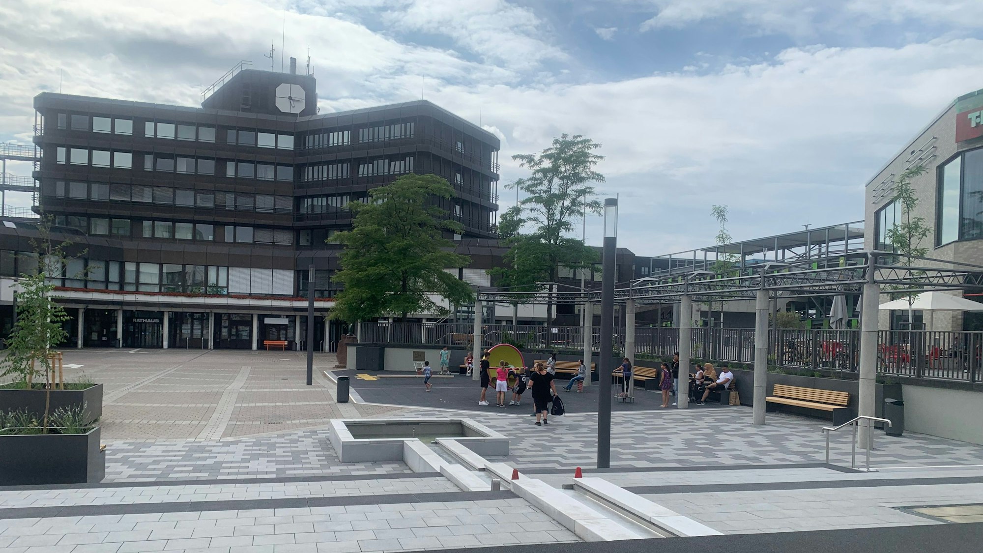 Ein moderner Innenstadtplatz, im Hintergrund ein Verwaltungsgebäude aus den 70er Jahren.