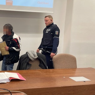 Der Angeklagte im Landgericht mit seinem Verteidiger Gordon Christiansen und zwei Wachtmeistern.