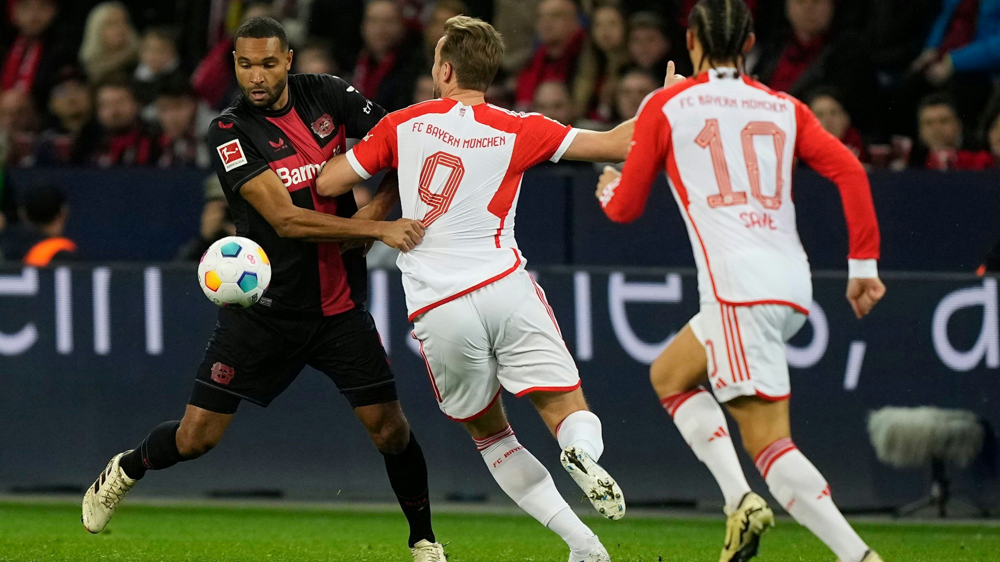 Leverkusens Jonathan Tah (l.) gegen Bayerns Harry Kane and Leroy Sane.AP