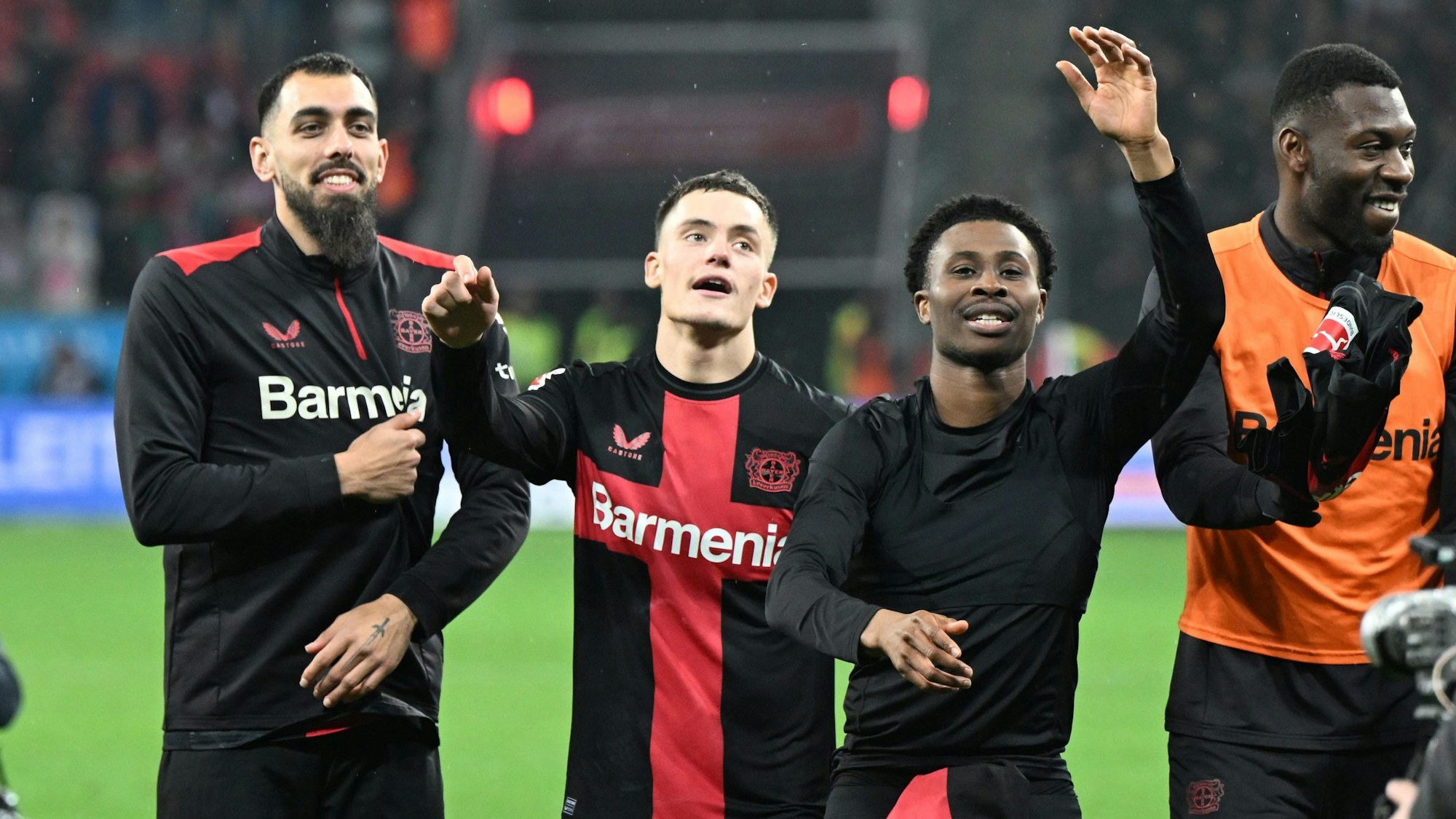 Leverkusens Borja Iglesias, Florian Wirtz und Nathan Tella (l-r) feiern nach dem Spiel.