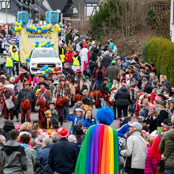 Eine Straße, voll mit Jecken. Ein Karnevalszug zieht durch den Ortskern in Hartegasse in Lindlar.