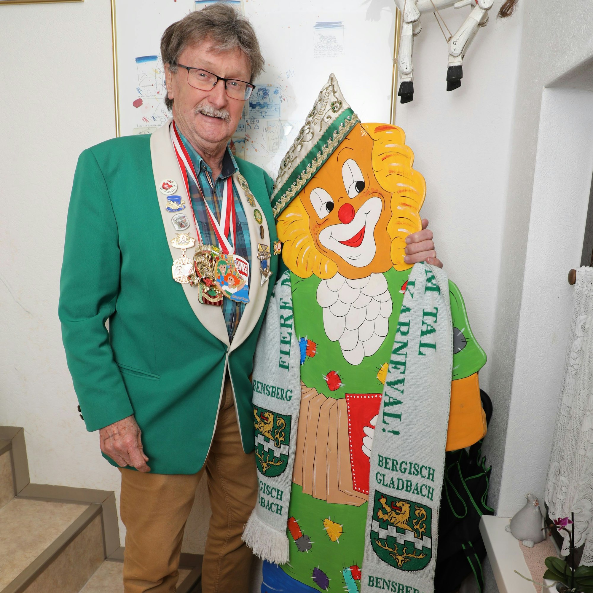 Zugleiter Helmut Kraus steht neben einer Clownsfigur im Treppenhaus seines Hauses.