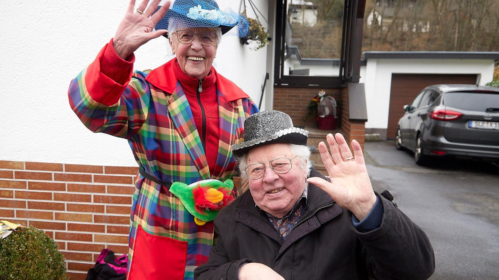 Alois Sommer und seine Frau haben bunte Hütchen auf und grüßen in die Kamera.