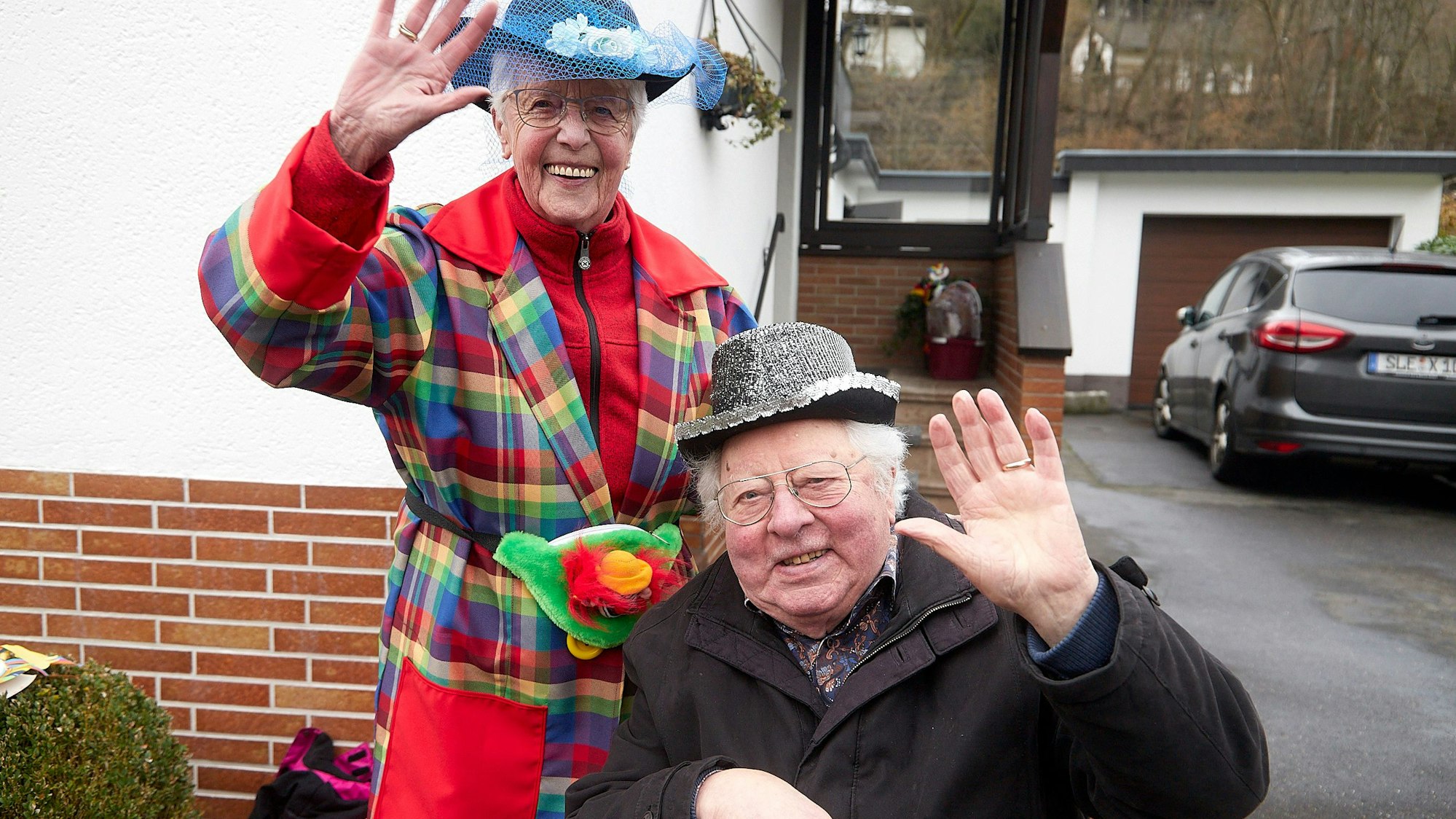 Alois Sommer und seine Frau haben bunte Hütchen auf und grüßen in die Kamera.