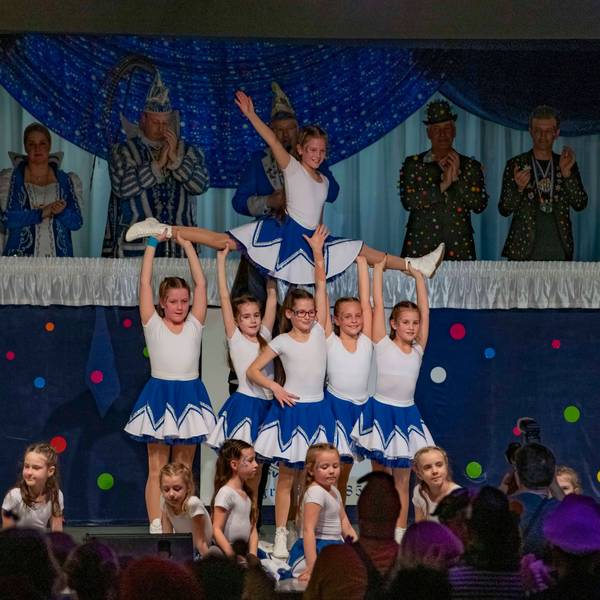 Eine Karnevals-Kindertanzgruppe zeigt eine Choreografie auf der Bühne einer Sitzung.