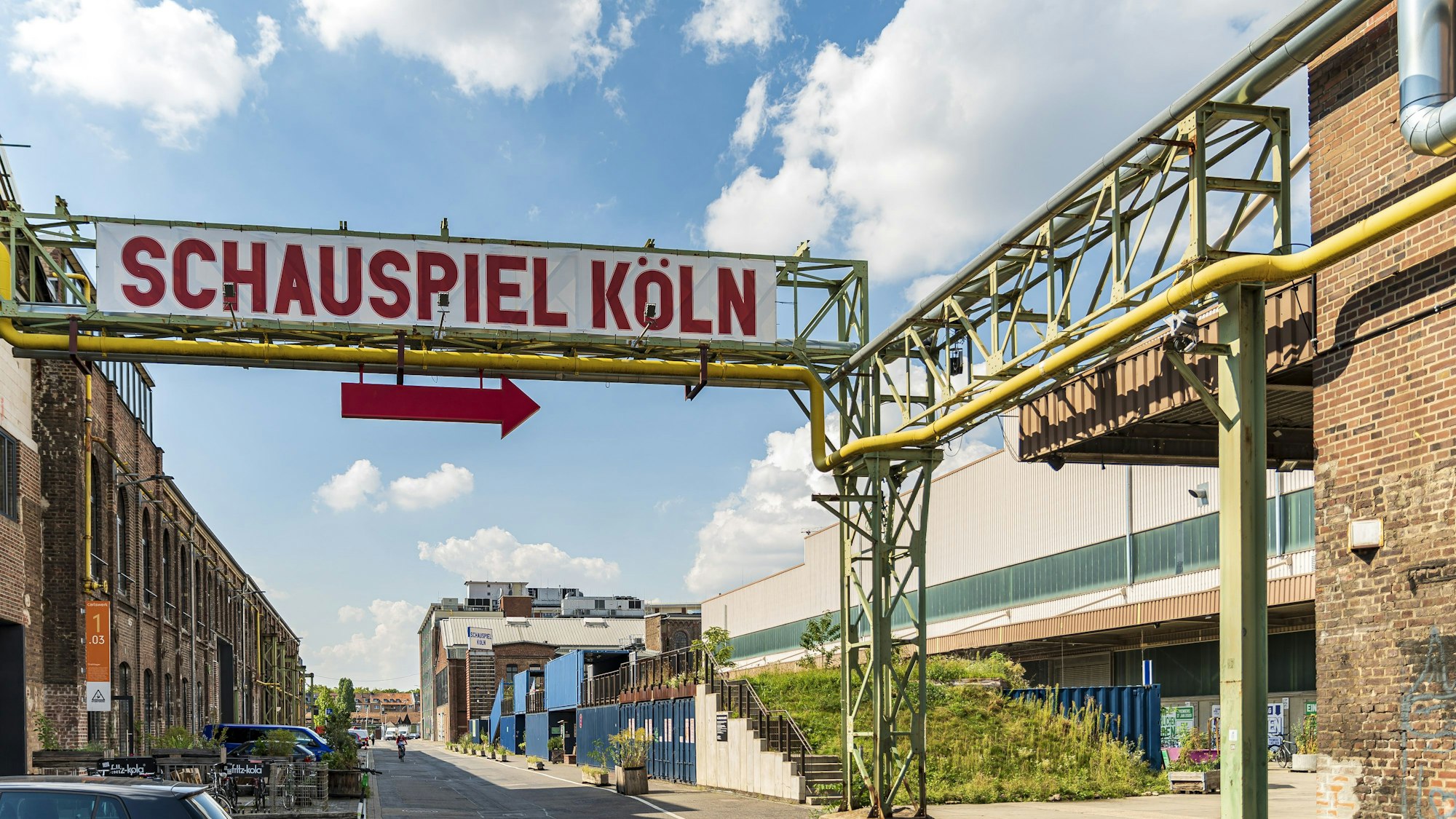 Schauspiel Köln: Ein großes Schild weist den Weg zur Spielstätte in einem ehemaligen Industrie-Gebäude.