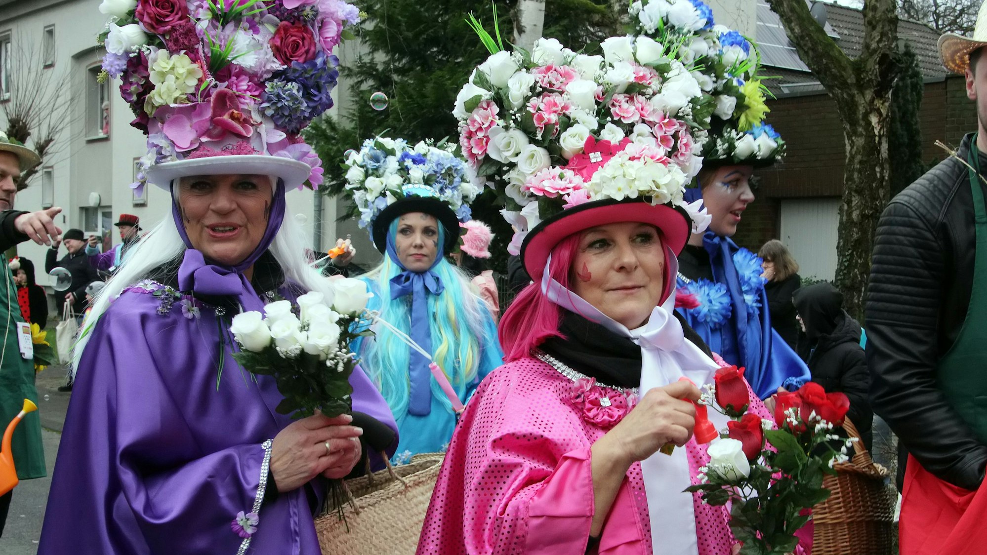 Närrinnen mit Blumensträußen auf dem Kopf.