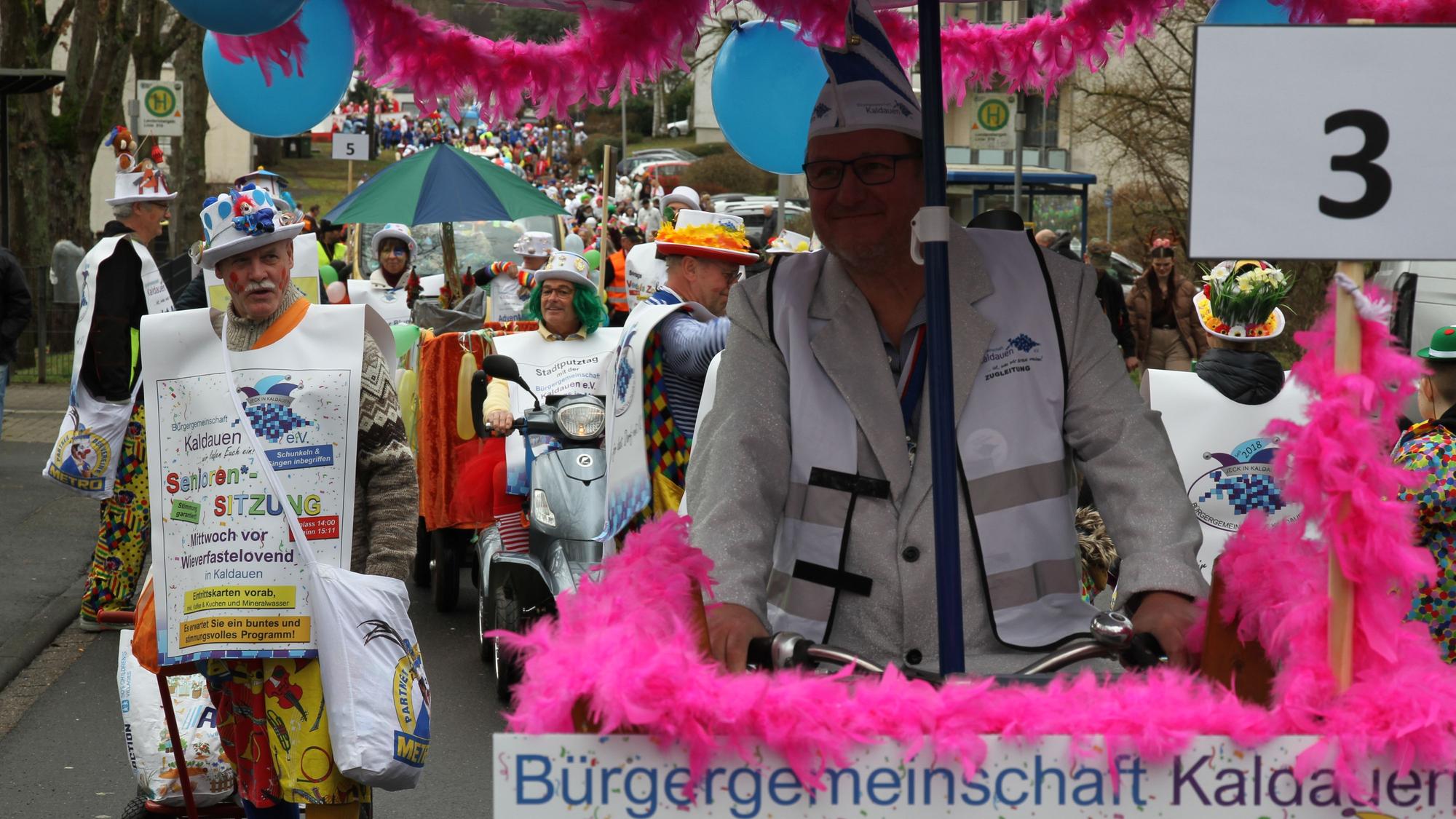 Blau-weiß kostümierte Jecke in einem Karnevalszug