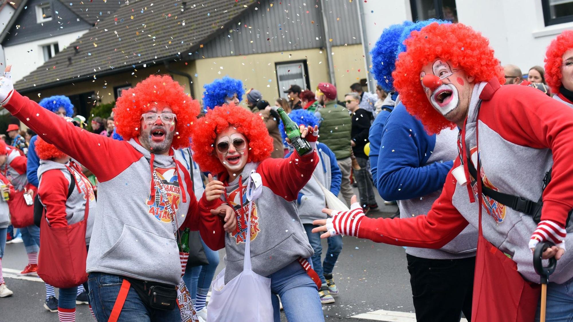 Mehrere Leute sind als Clowns verkleidet und schießen Konfetti in die Luft.