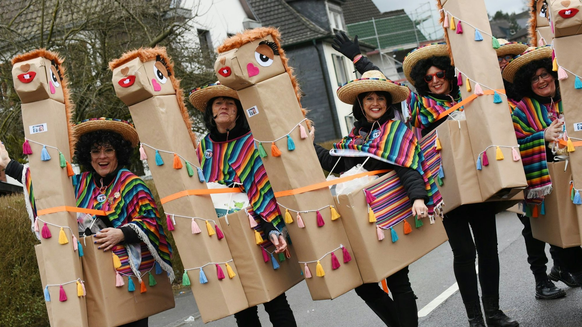 Eine Gruppe Kostümierter reitet auf selbstgebastelten Alpakas.
