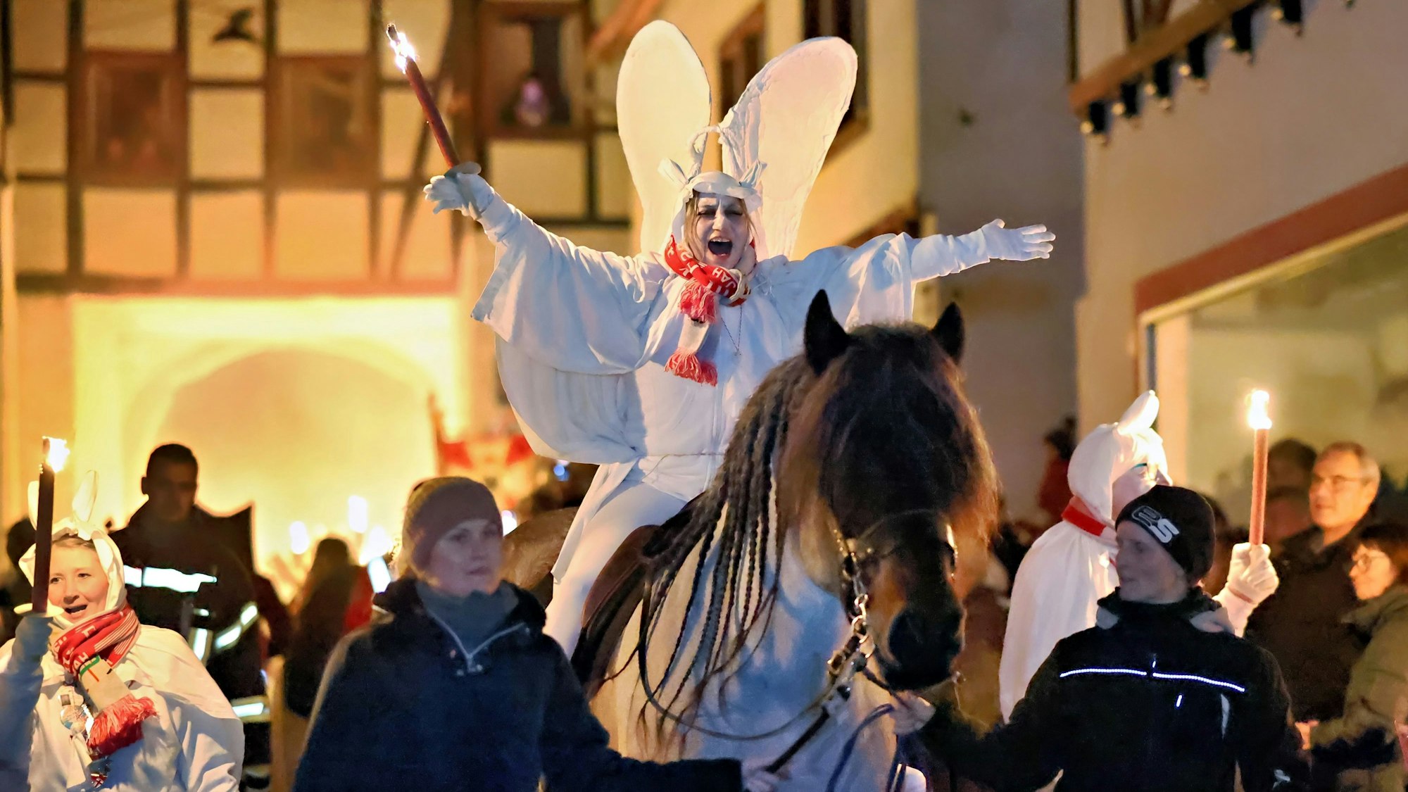 Als weißer Geist verkleidet und mit Flügeln auf dem Rücken reitet Blankenheims Prinzessin Dilek I. (Schröder-Tas) an der Spitze des Geisterzugs. Ihr Pferd wird von zwei Helferinnen geführt.